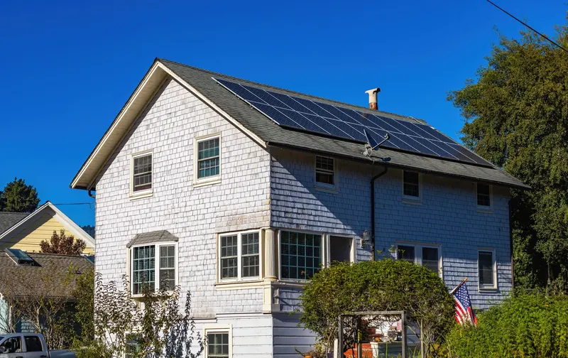 White clapboard house with solar panels on the roof