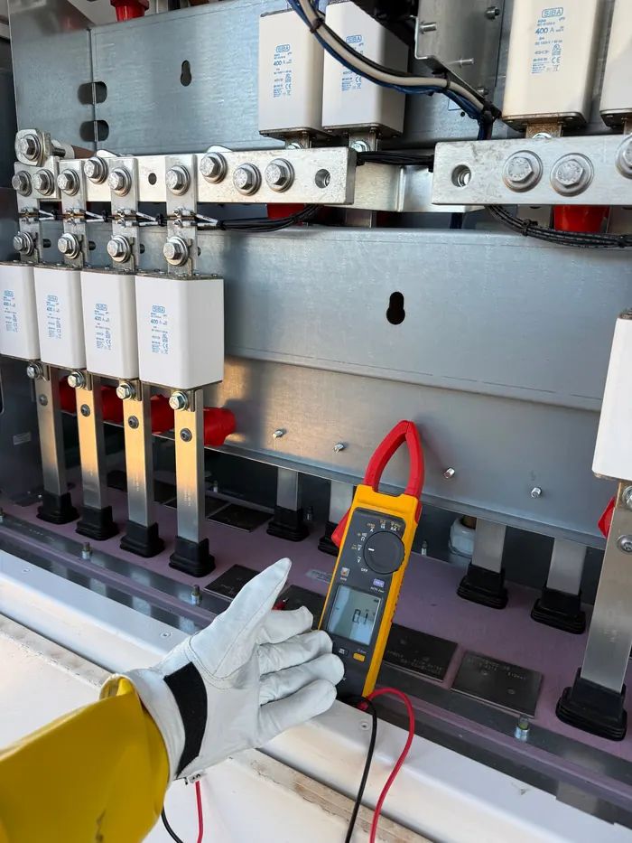 Technician measuring voltage at an electrical panel